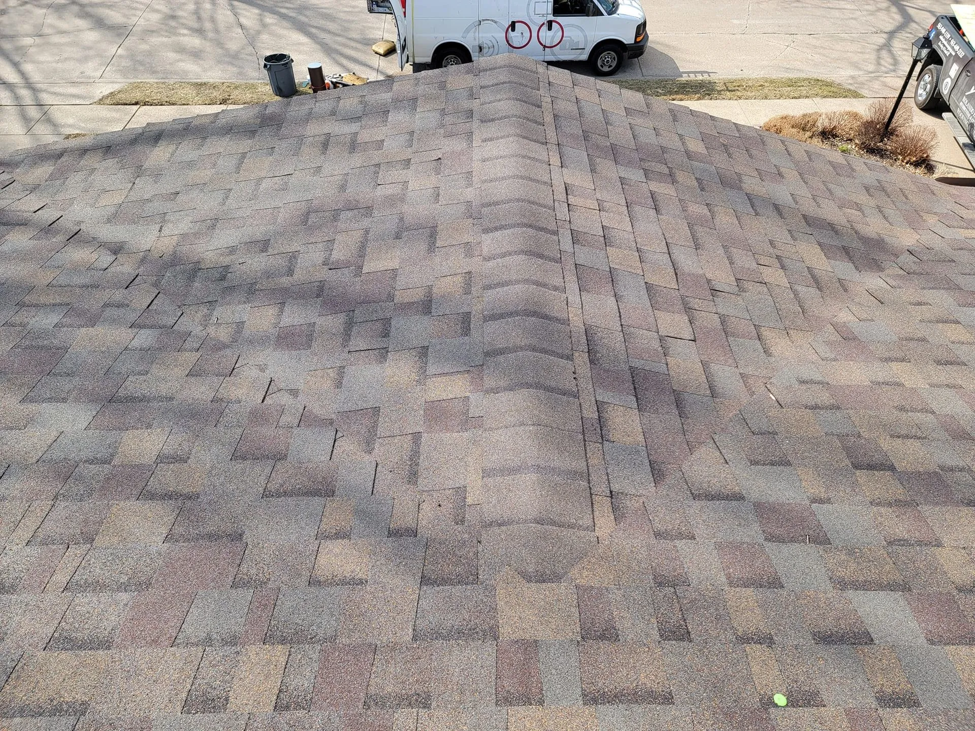 A white van is parked on the roof of a house.