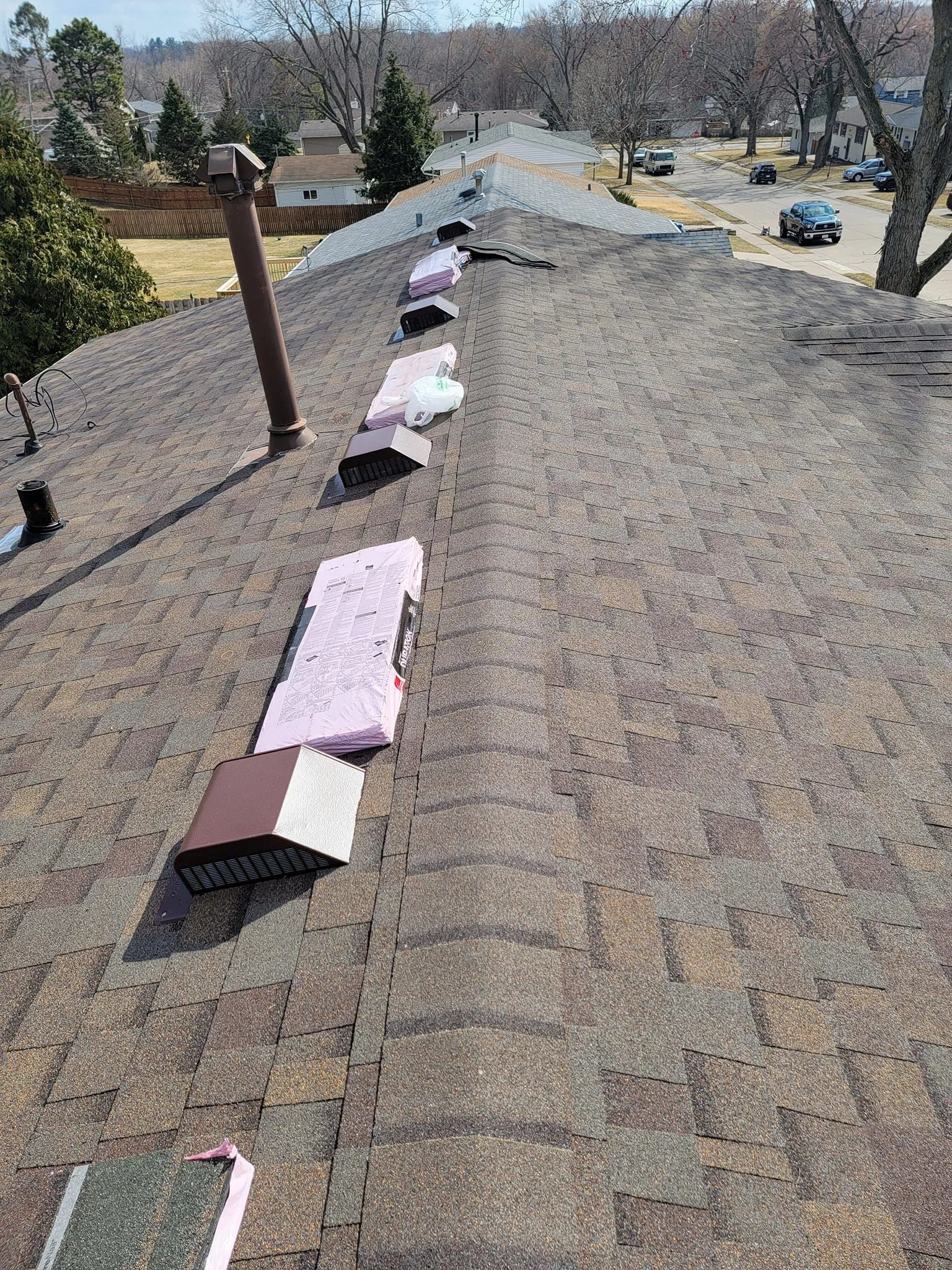 A roof with a lot of shingles and a chimney on it.