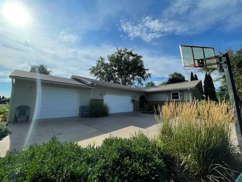 Ranch home with a double garage and a newly installed shingle roof