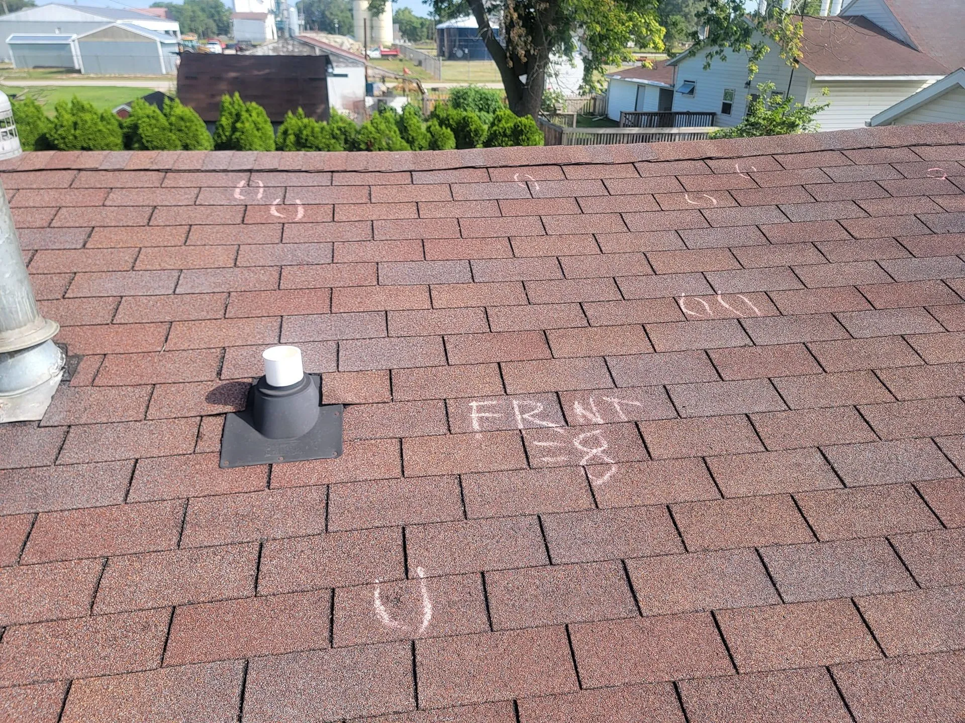 Red shingle roof with chalk marks and "FRONT" written during a roof inspection